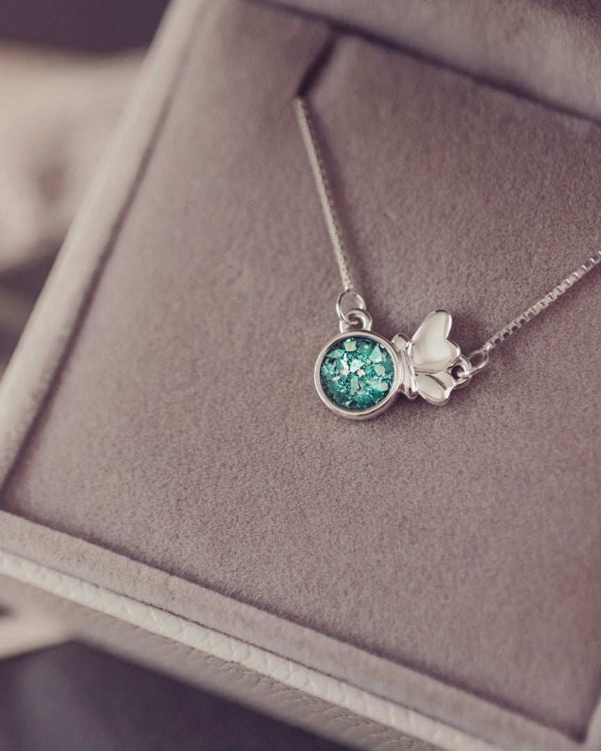 Necklace with a green gemstone pendant on a soft surface