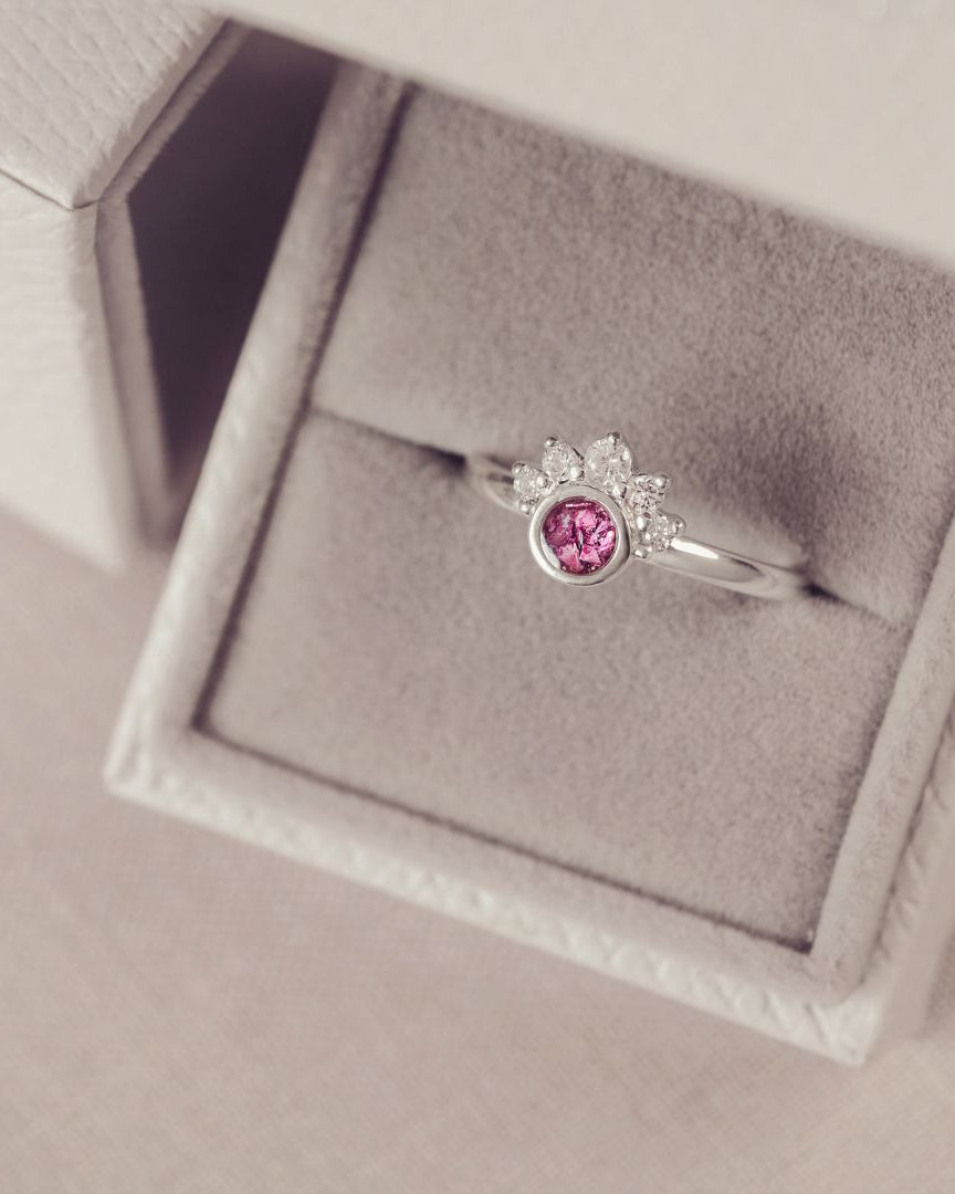 Silver ring with a pink gemstone in a jewelry box