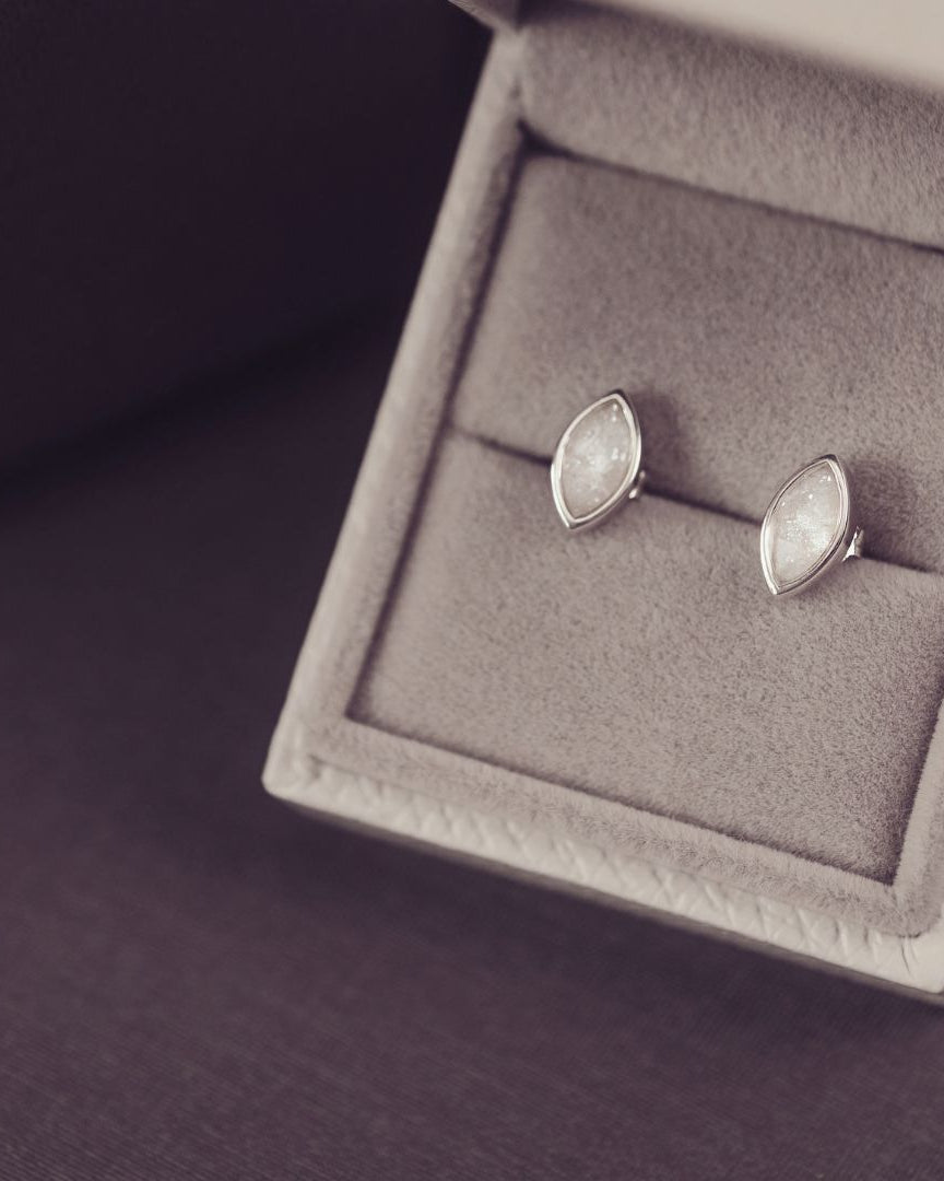 Silver earrings in a jewelry box on a dark background
