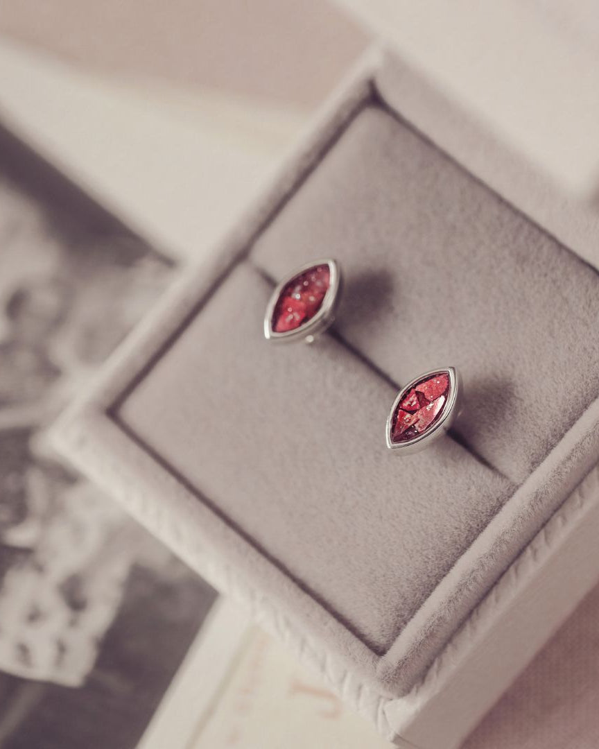 Pair of silver earrings with red gemstones in a box