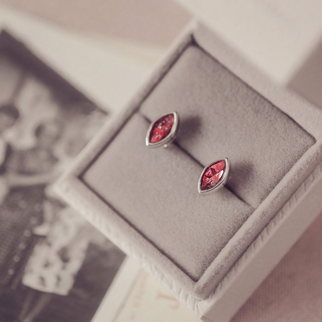 Pair of silver earrings with red gemstones in a box