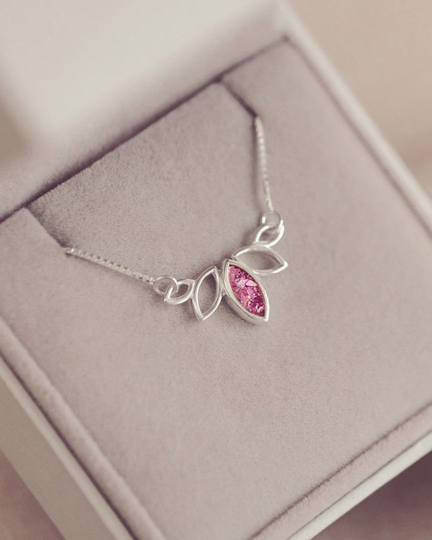 Silver necklace with a pink gemstone in a jewelry box