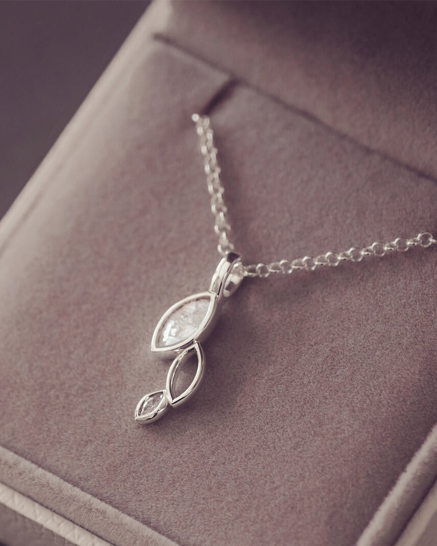 sterling silver necklace featuring gem stone, cremation ashes, clear crystal and resin laying in a grey jewellery box