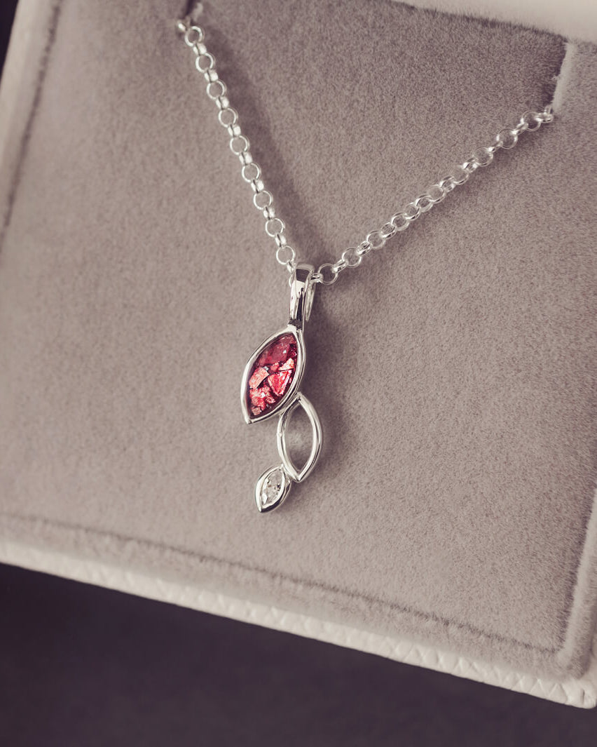 sterling silver necklace featuring gem stone, cremation ashes, red crystal and resin sat in a grey jewellery box