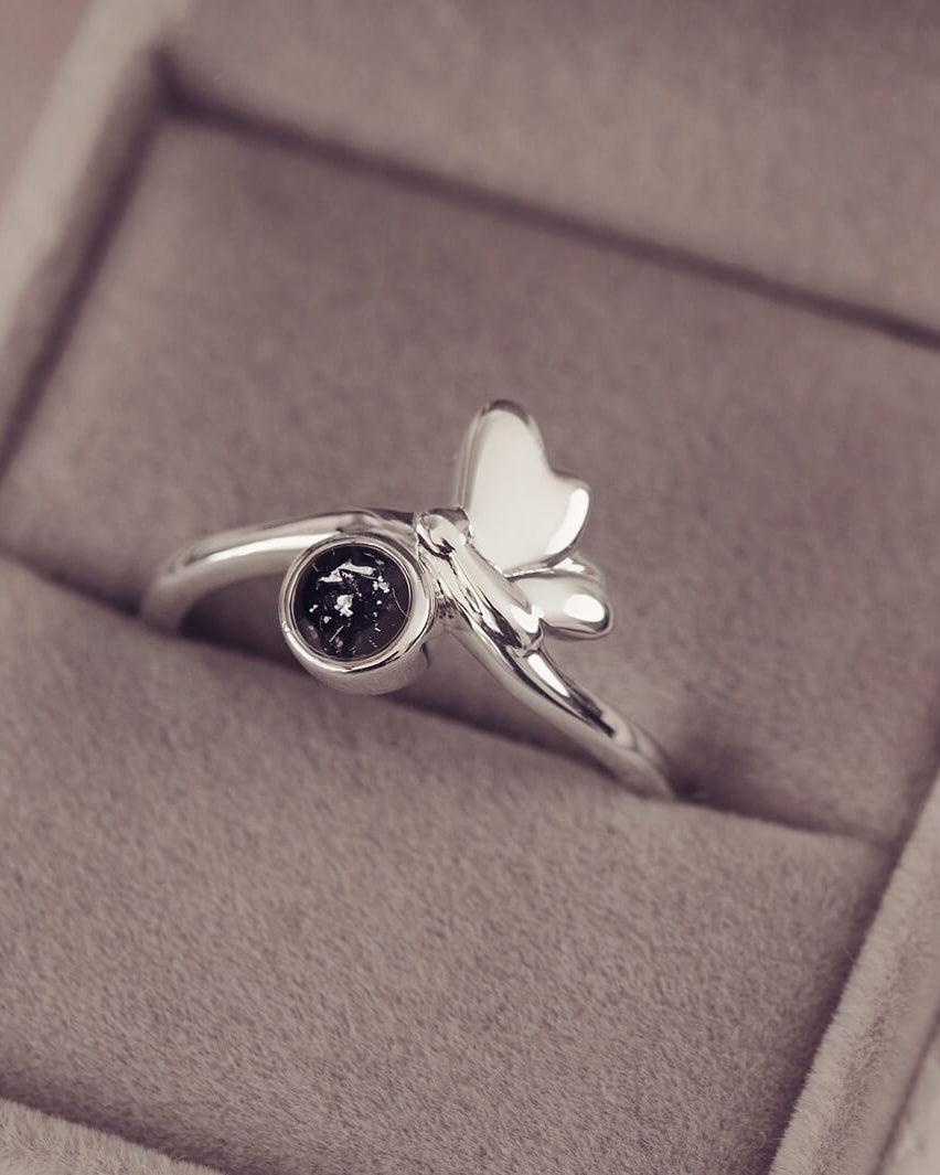 Silver butterfly ring with black floating crystals and cremation ashes in a grey jewellery box