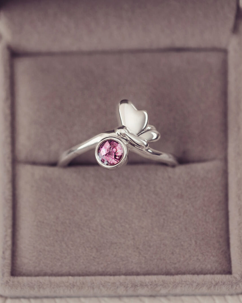 Silver butterfly ring with pink crystals and cremation ashes in a grey jewellery box
