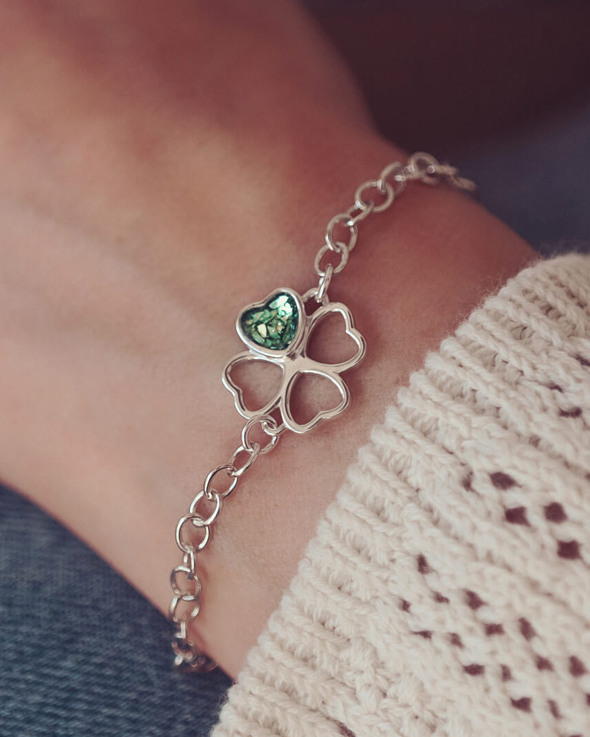 sterling silver chain bracelet with clover shaped charm holding green crystal and cremation ashes