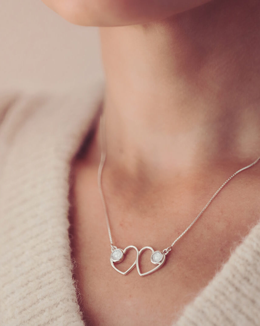 Cremation Ashes Double Infinity Heart Necklace on a silver chain, worn around a ladies neck