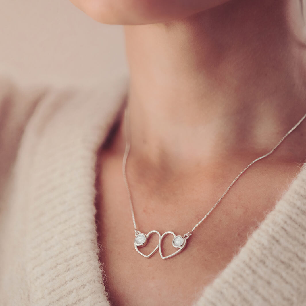 Cremation Ashes Double Infinity Heart Necklace on a silver chain, worn around a ladies neck