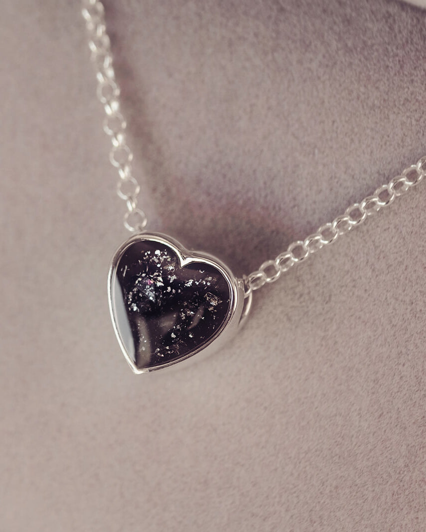 black heart pendant, filled with crystals, glitter and memorial ashes, on a silver chain.