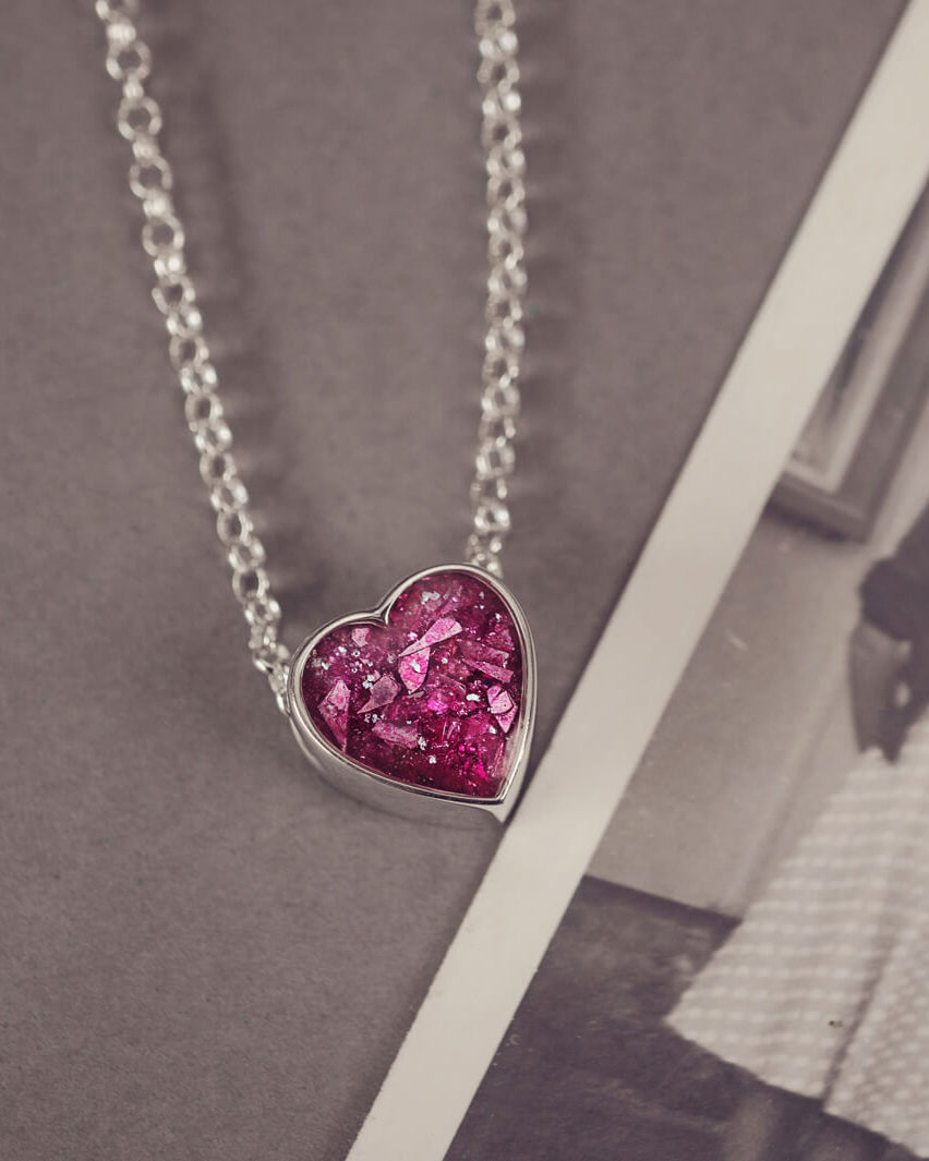 pink heart pendant, filled with crystals, glitter and memorial ashes, on a silver chain.