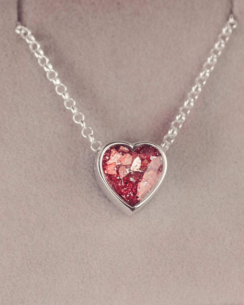 Red heart pendant, filled with crystals, glitter and memorial ashes, on a silver chain.