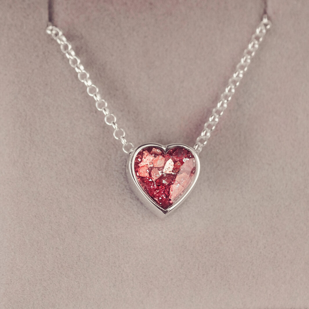 Red heart pendant, filled with crystals, glitter and memorial ashes, on a silver chain.