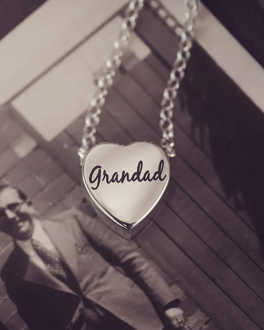 silver heart pendant on a silver chain with the message 'Grandad' engraved on the reverse