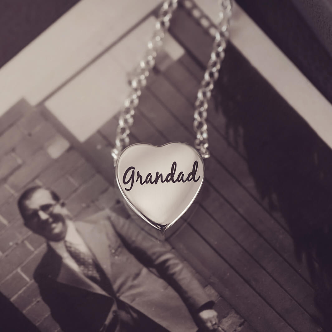 silver heart pendant on a silver chain with the message 'Grandad' engraved on the reverse