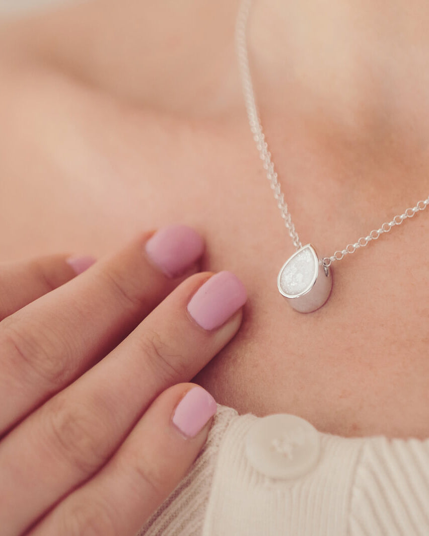 Cremation Ashes Floating Peardrop Necklace, in clear, on a sterling silver chain on a ladies neck