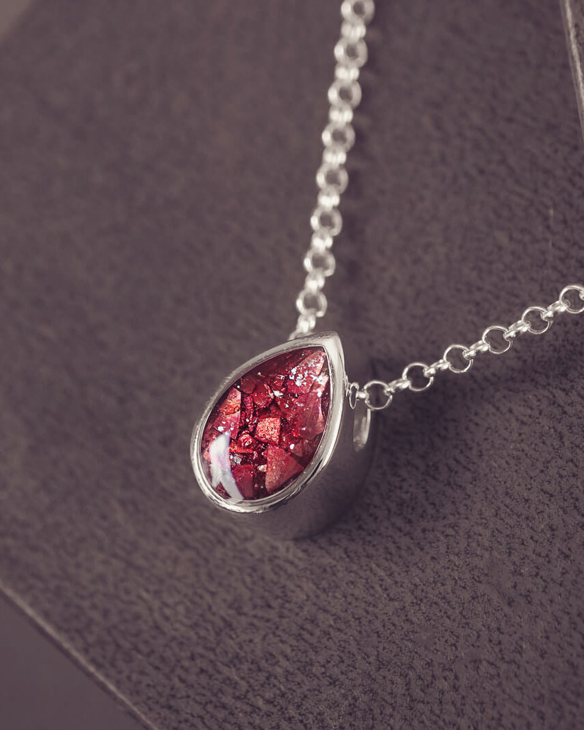 Peardrop shaped silver pendant, filled with red crystal & cremation ashes, on a silver chain