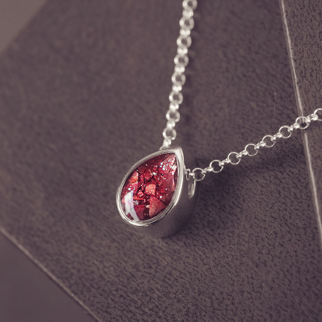 Peardrop shaped silver pendant, filled with red crystal & cremation ashes, on a silver chain