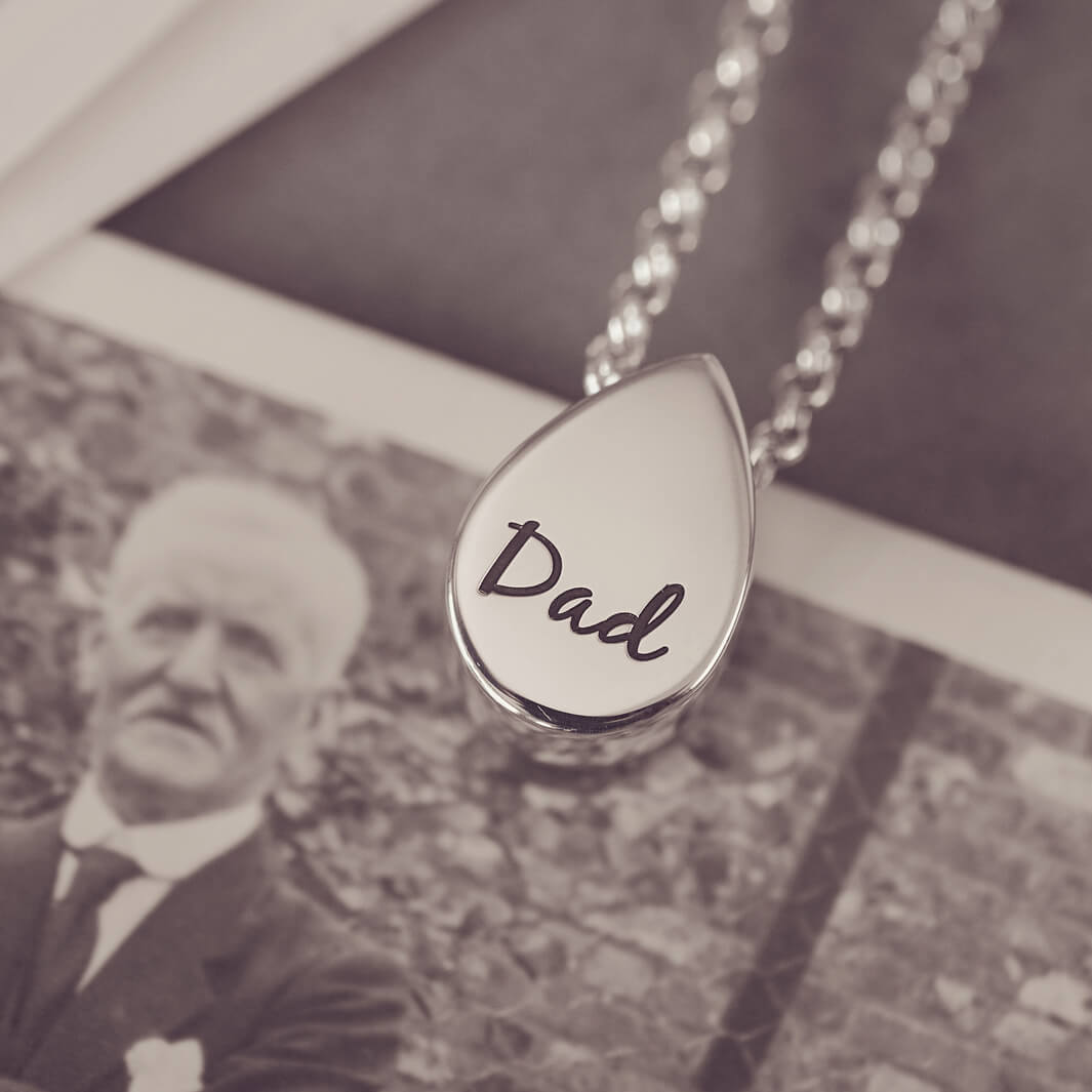Peardrop shaped silver pendant, with 'Dad' engraved onto the reverse, on a silver chain
