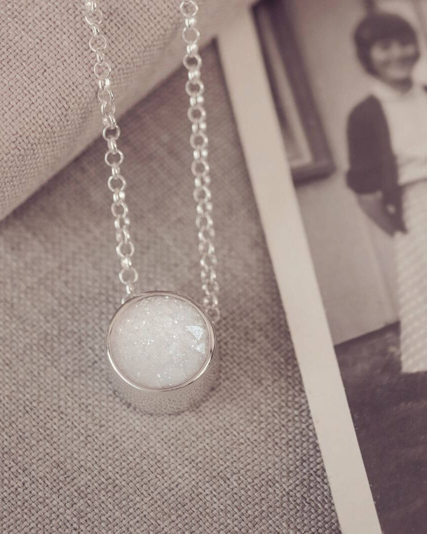 Round silver charm on silver chain, filled with clear and white crystal, glitter, resin & ashes.