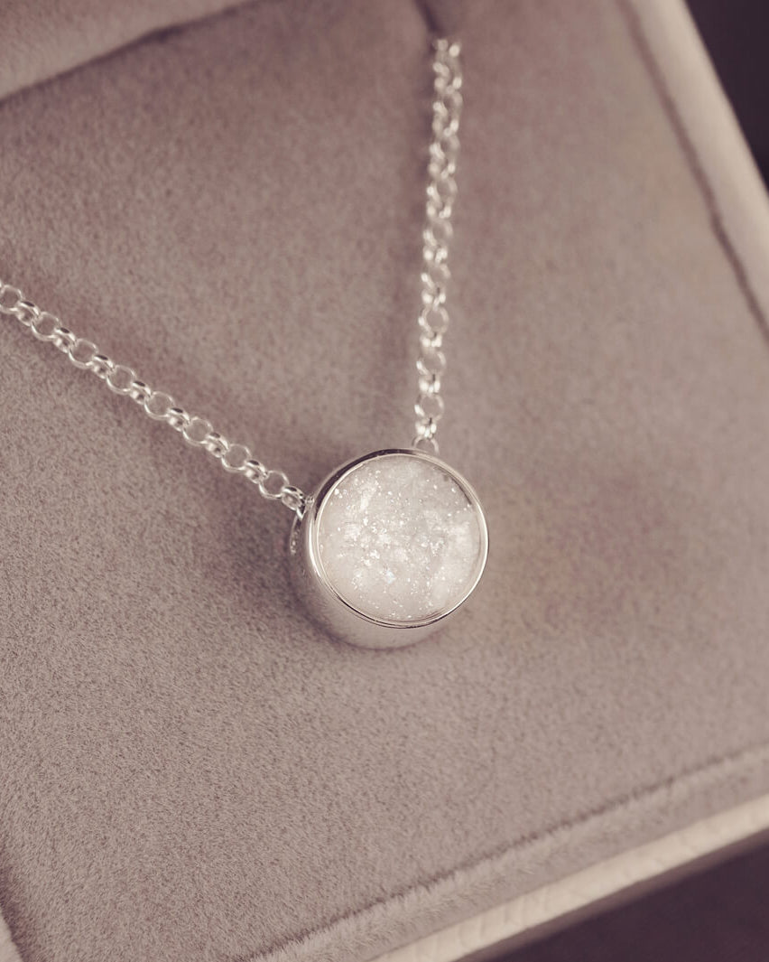 Round silver charm on silver chain, filled with clear and white crystal, glitter, resin & ashes.