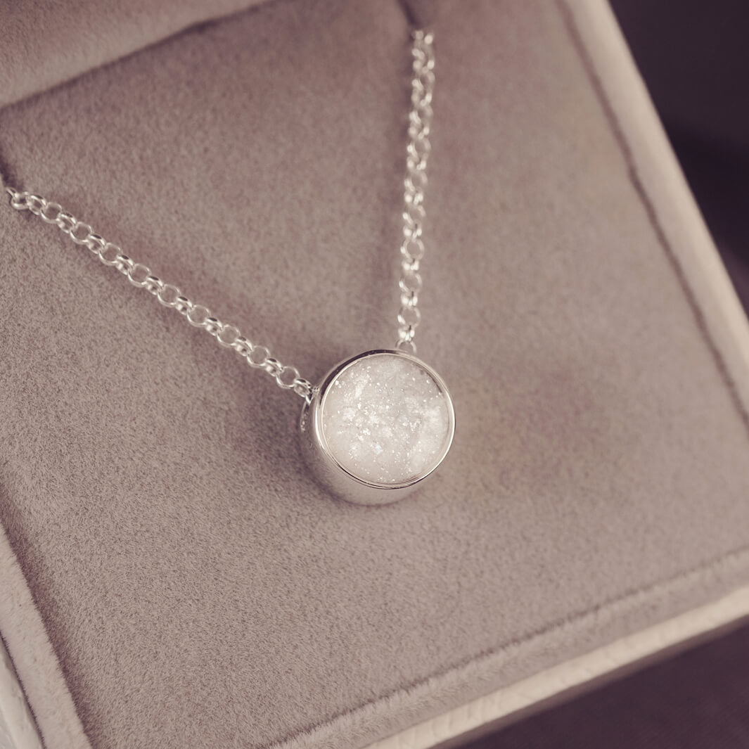 Round silver charm on silver chain, filled with clear and white crystal, glitter, resin & ashes.
