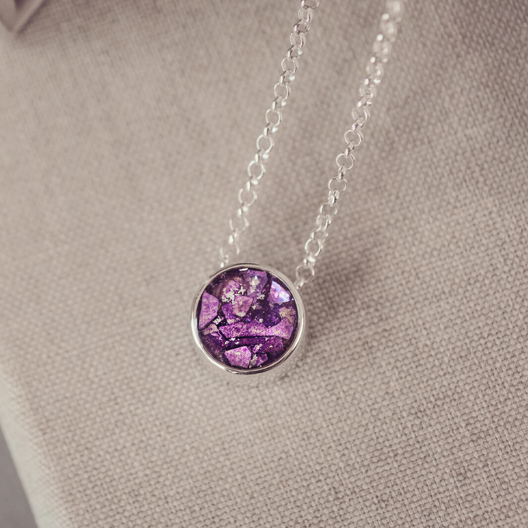Round silver charm on silver chain, filled with purple crystal, glitter, resin & ashes.