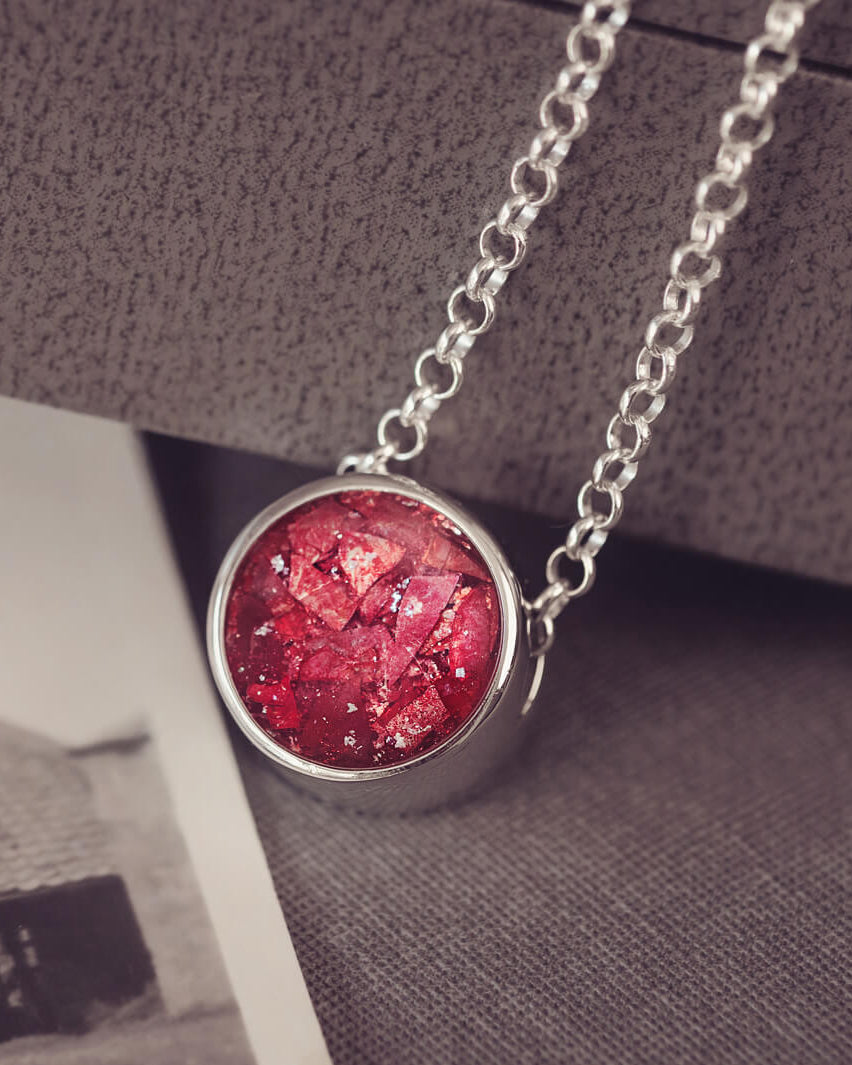 Round silver charm on silver chain, filled with red crystal, glitter, resin & ashes.