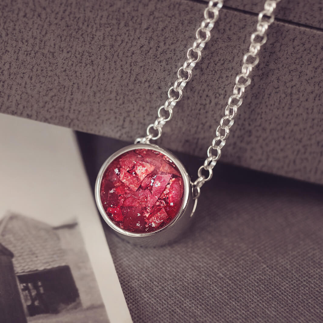 Round silver charm on silver chain, filled with red crystal, glitter, resin & ashes.