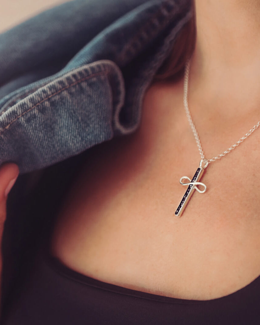 Cremation Ashes Infinity Cross Necklace, worn on a silver chain around a ladies neck