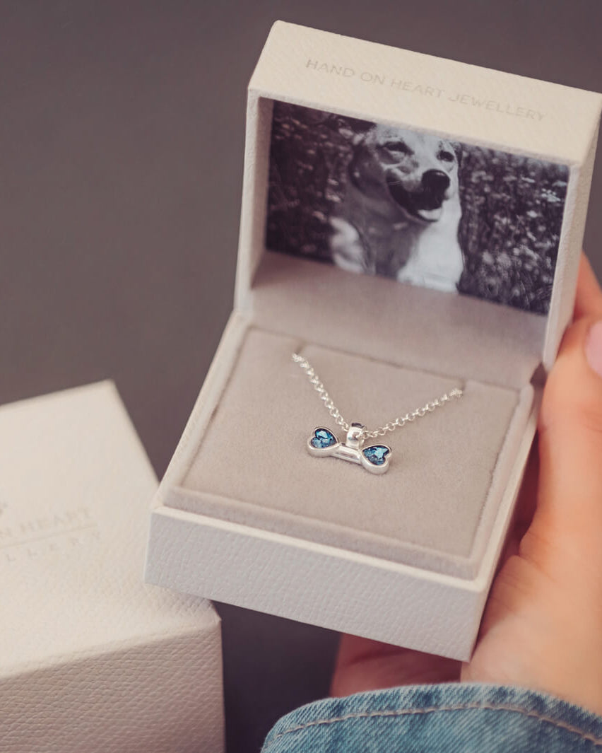 sterling silver bone shaped necklace, filled with cremation ashes, blue crystal and resin in a jewellery box