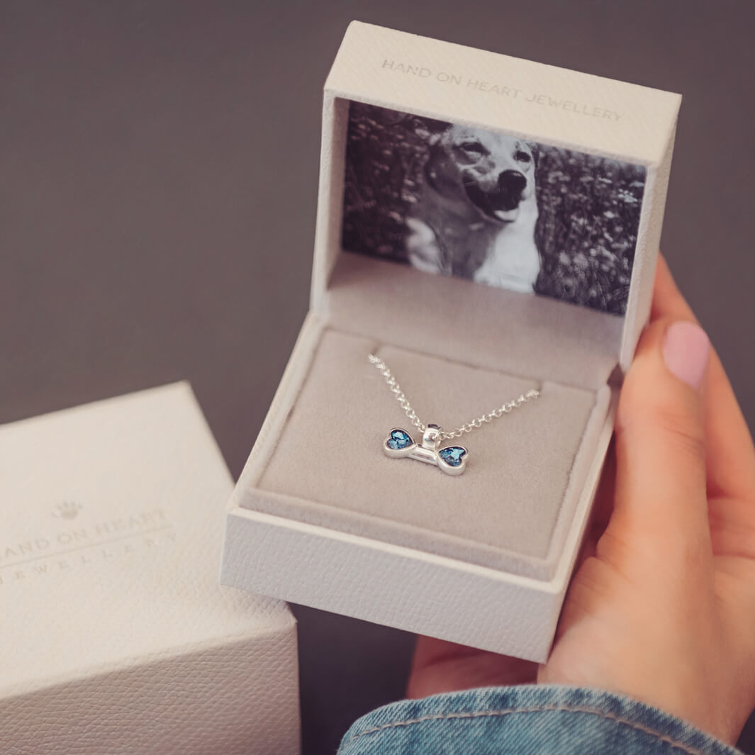 sterling silver bone shaped necklace, filled with cremation ashes, blue crystal and resin in a jewellery box