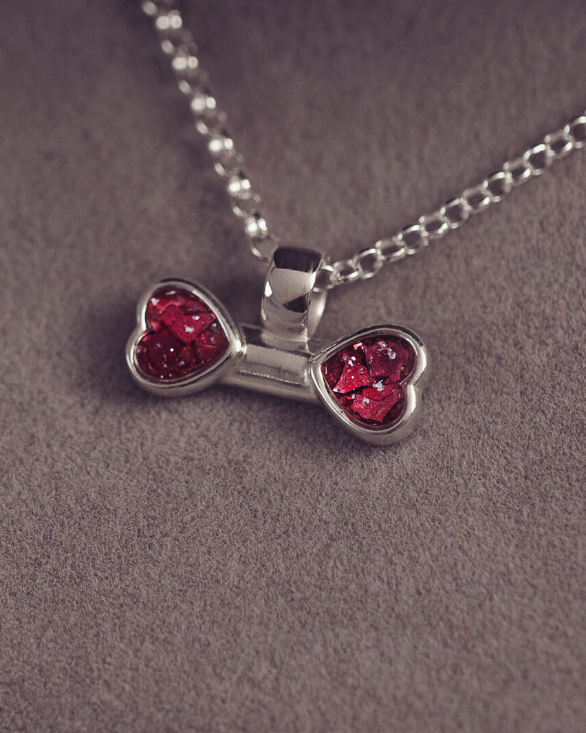 sterling silver bone shaped necklace, filled with cremation ashes, red crystal and resin.