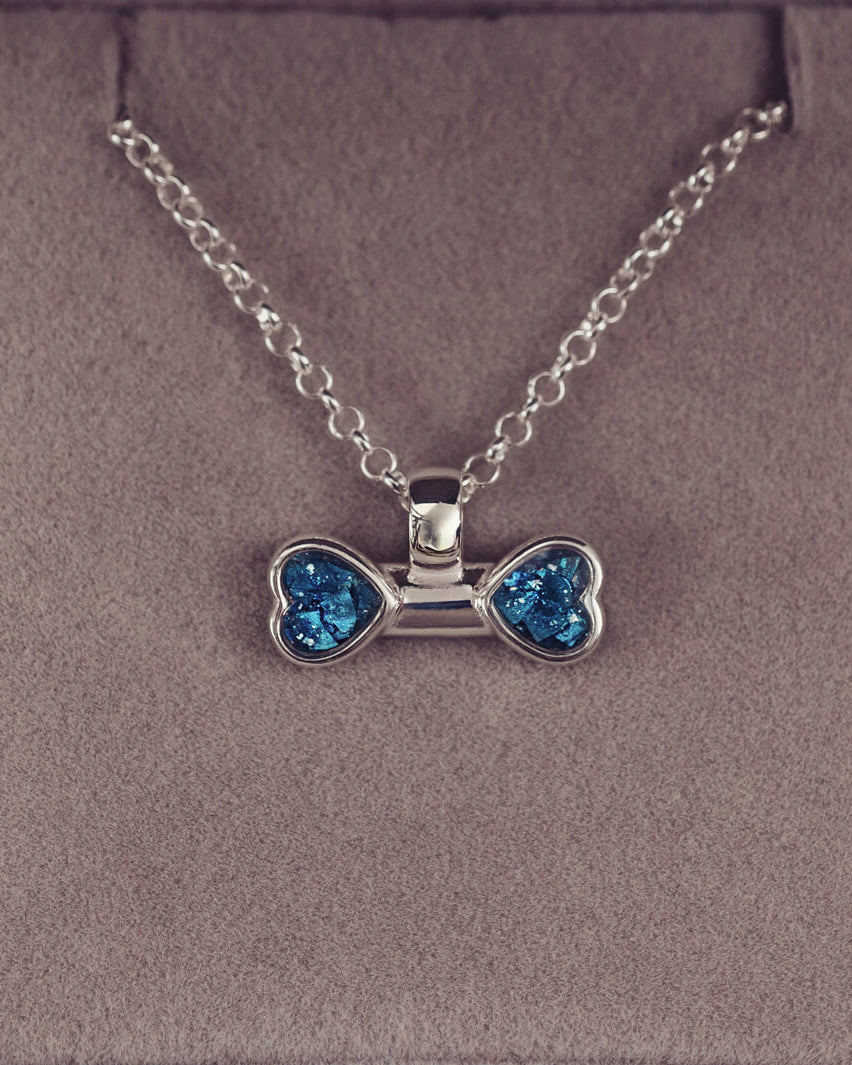 sterling silver bone shaped necklace, filled with cremation ashes, blue crystal and resin.
