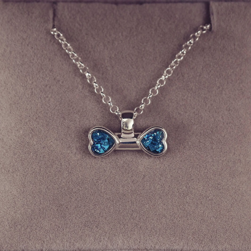 sterling silver bone shaped necklace, filled with cremation ashes, blue crystal and resin.