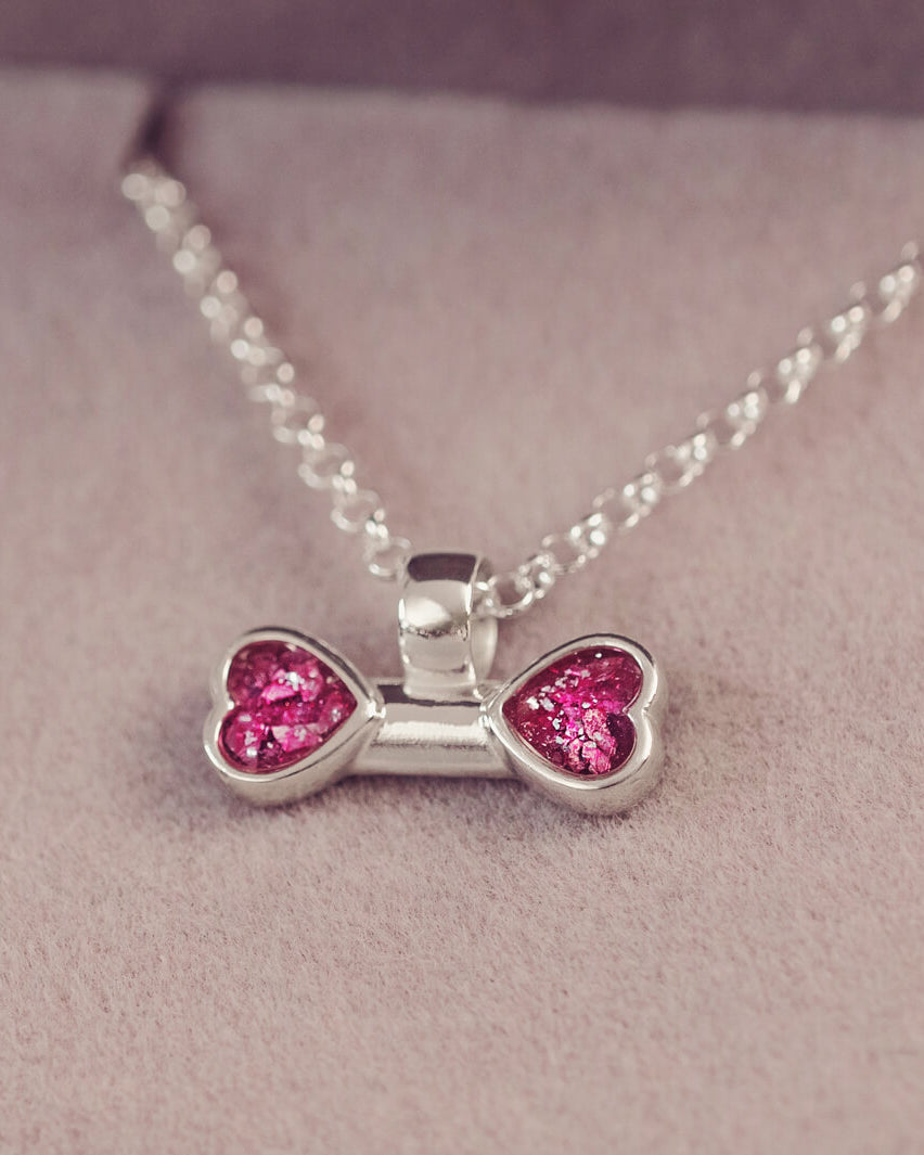 sterling silver bone shaped necklace, filled with cremation ashes, pink crystal and resin.