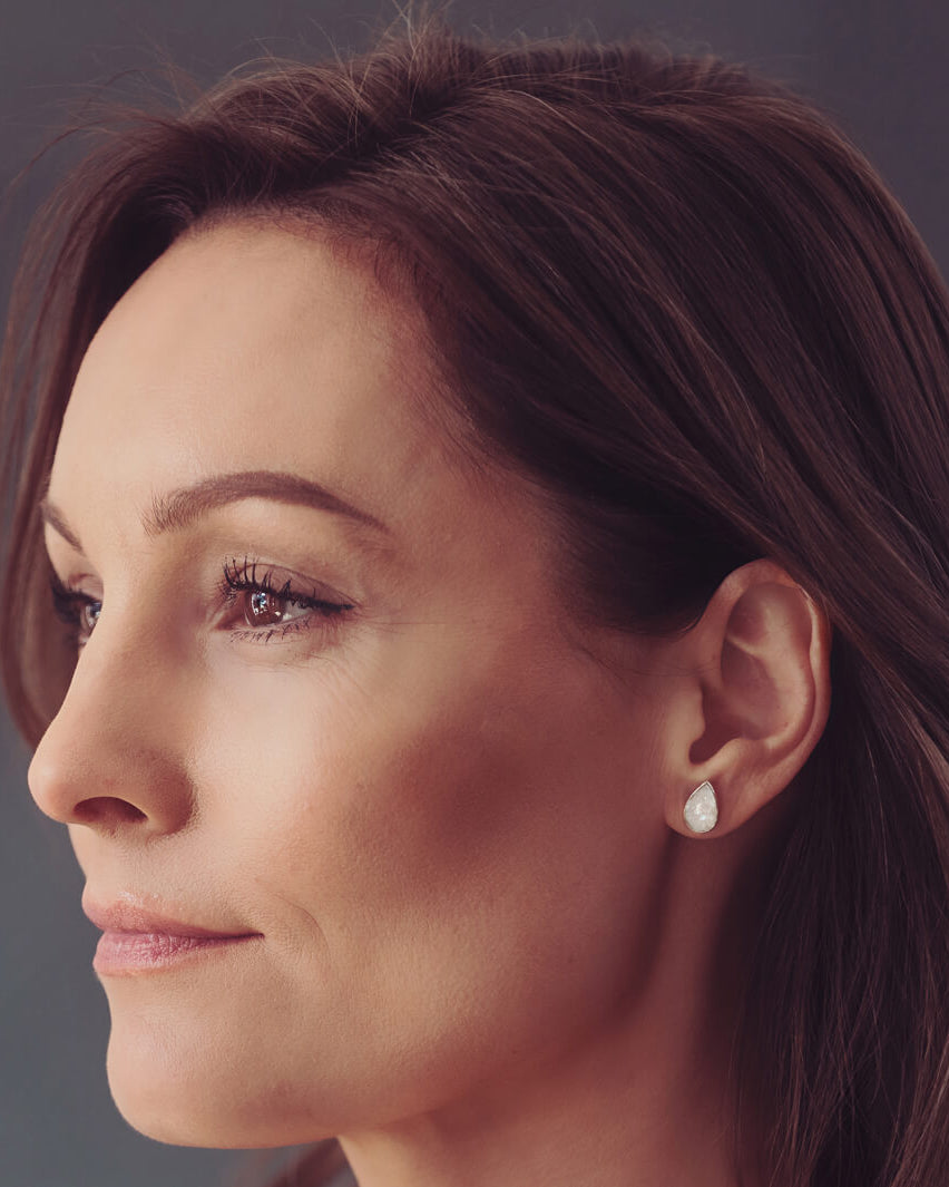 Cremation Ashes Teardrop Earrings with clear crystal, being worn in a ladies ear