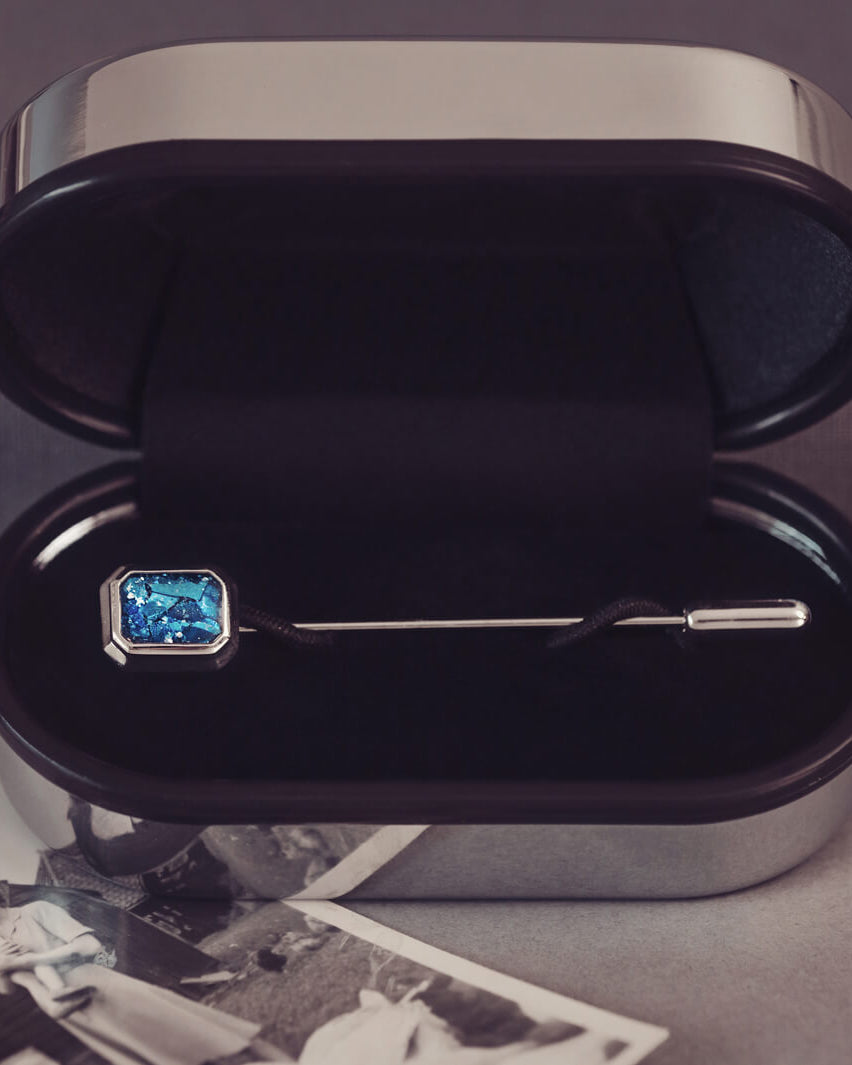 silver ashes tie pin, in a presentation case, filled with blue crystal and cremation ashes