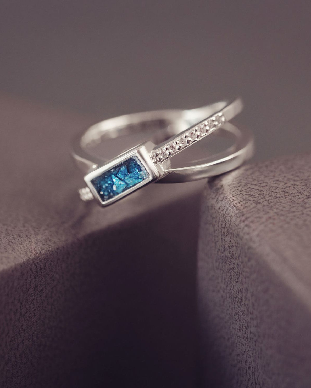 Silver ring with a blue gemstone on a textured surface