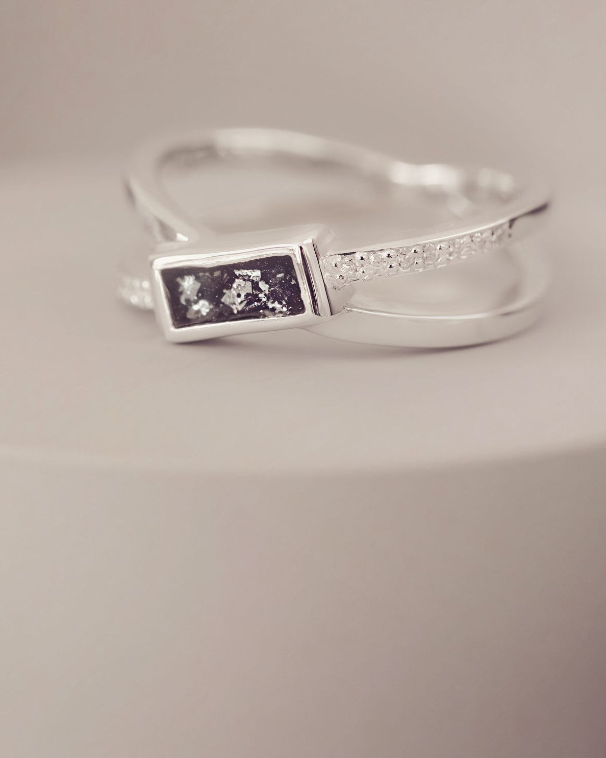 Silver ring with a rectangular design on a neutral background