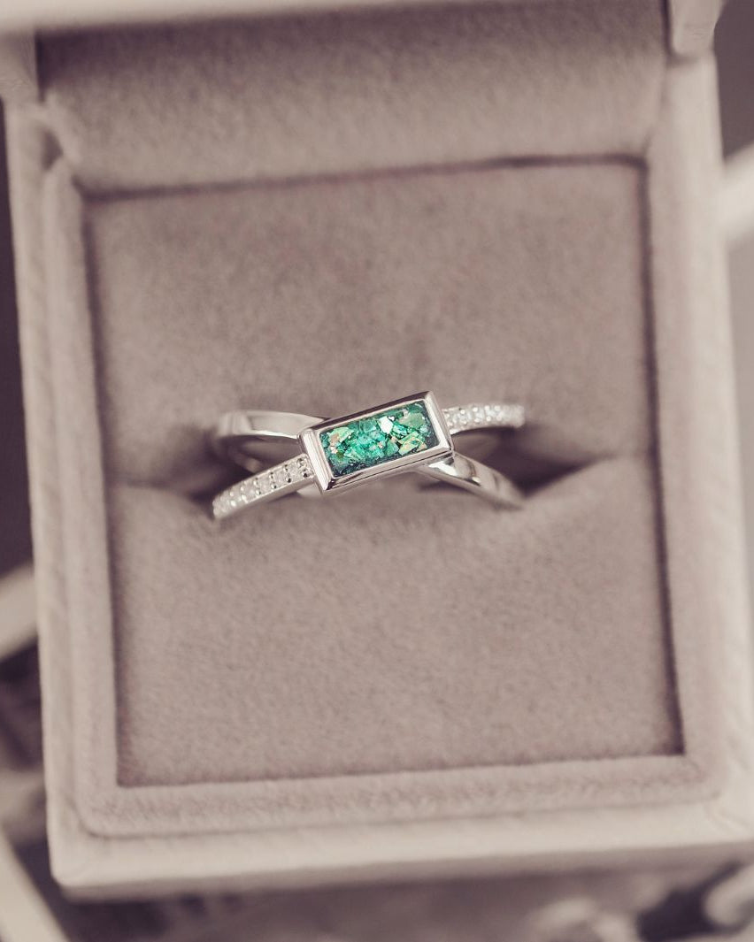 Silver ring with a green gemstone in a jewelry box