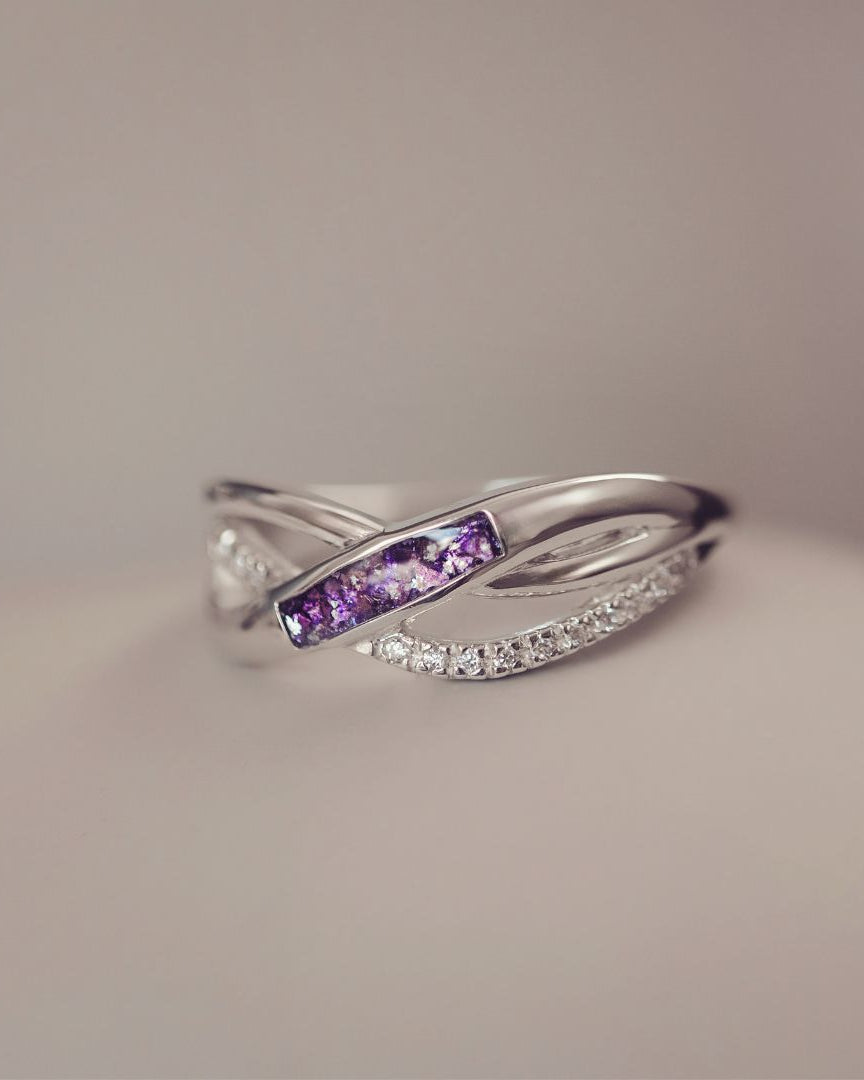 Silver ring with purple gemstones on a neutral background
