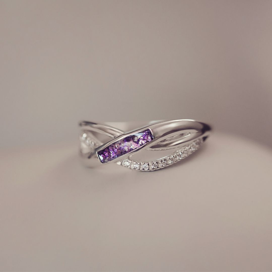 Silver ring with purple gemstones on a neutral background