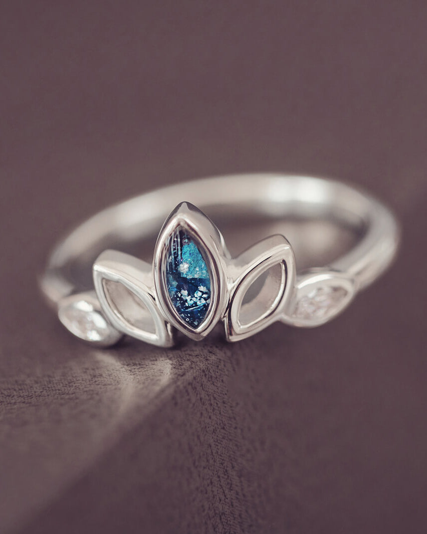 Sterling Silver Ring, created with your loved ones ashes, with Cubic Zircona gemstones. Blue floating crystals with in piece on a grey background