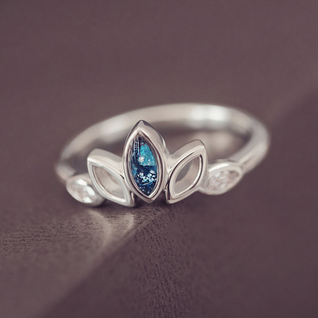 Sterling Silver Ring, created with your loved ones ashes, with Cubic Zircona gemstones. Blue floating crystals with in piece on a grey background