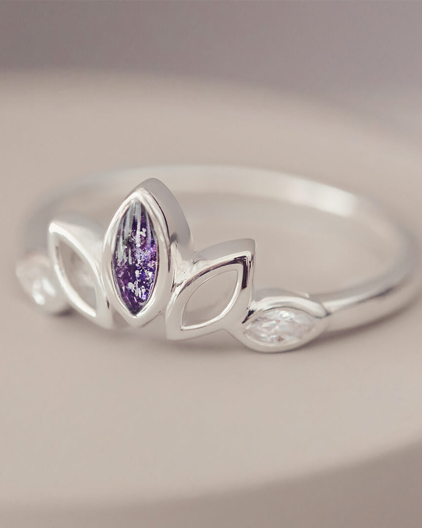 Sterling Silver Ring, created with your loved ones ashes, with Cubic Zircona gemstones. Purple floating crystals with in piece on a grey background
