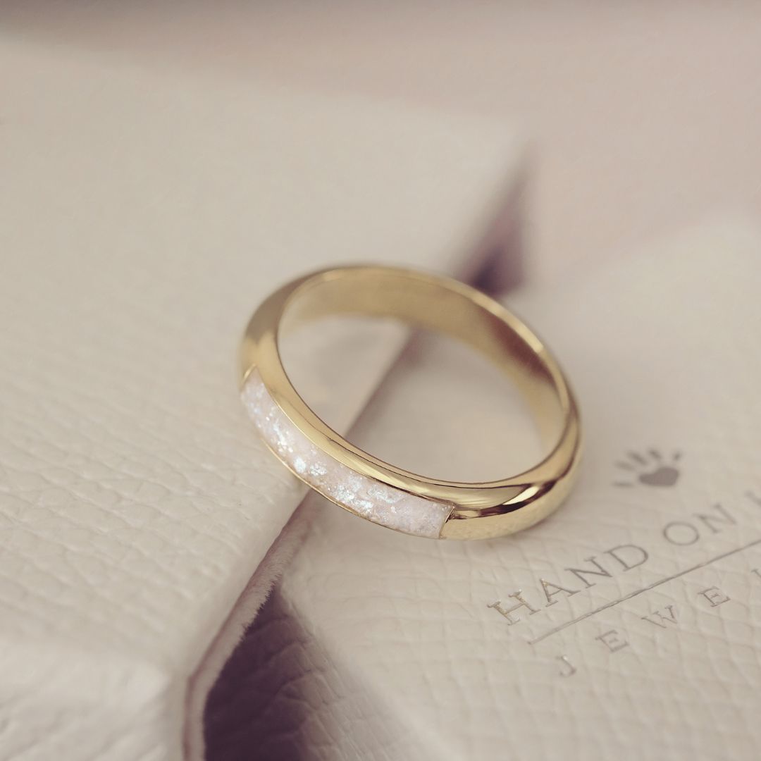 Gold ring with a white stone on a light background