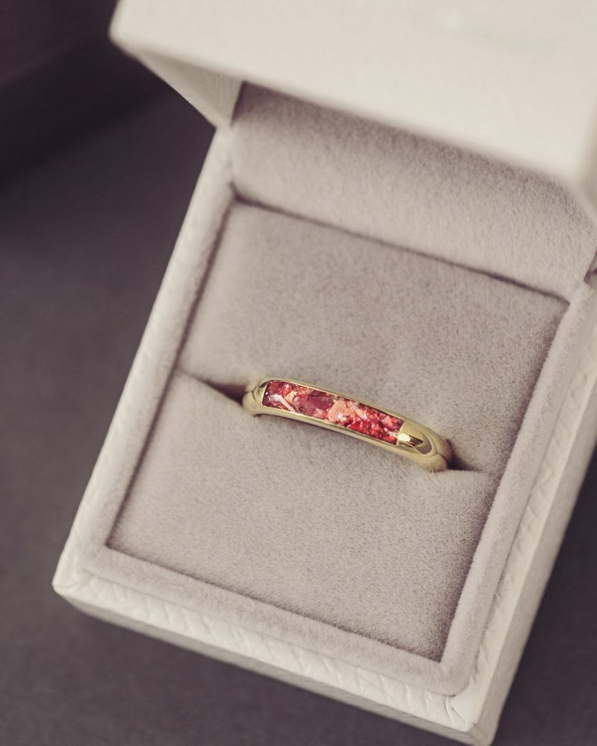 Gold ring with red gemstone in a jewelry box