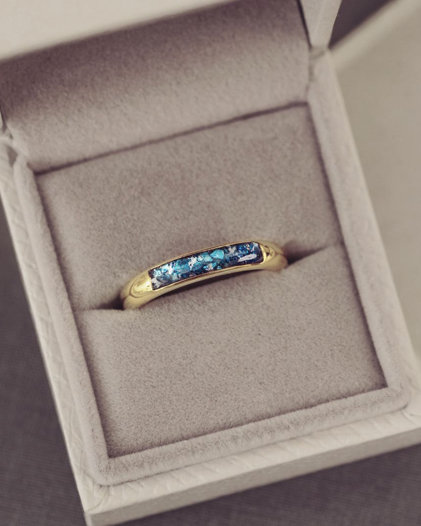 Gold ring with blue gemstones in a jewelry box
