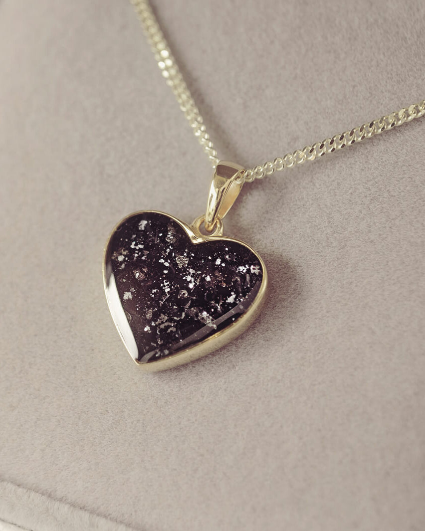 gold heart necklace filled with black crystals, resin and cremation ashes